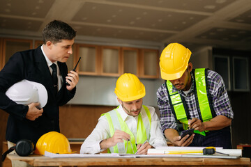 Contractor and architect looking at plan, tablet, laptop and talking about working on big project....