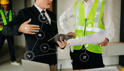 Creative architect projecting on the big drawings in the dark loft office with VR icon  in morning light.