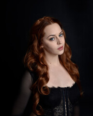 close up portrait of beautiful woman with long red hair wearing sheer corset top. variety of facial expressions,  Isolated on dark studio background with moody silhouette lighting.