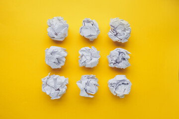 Crumpled paper balls on yellow background. Brain storming and idea concept