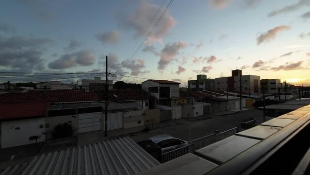 Sunset Time lapse from the window of a small apartment looking out at the poor community of Valentina in the beach capital Joao Pessoa in Paraiba, Brazil on a warm summer evening.