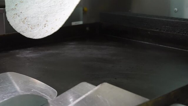 Flipping a hot flour tortilla on the flat top griddle - food truck series