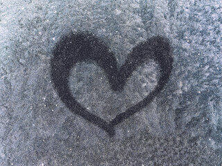 Texture of ice on a window with a drawn heart