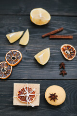 Handmade soap bars and citrus fruit on dark table top view. Piece of handmade lemon soap and fresh lemons