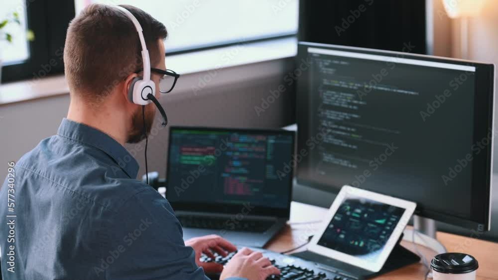 Poster programmer is working in the modern office. sitting by computer.