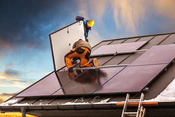 Naklejka premium Workers assemble photovoltaic panels on the roof of the building