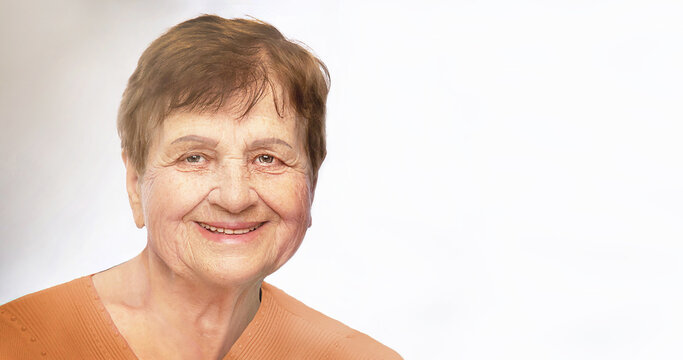 Portret of smiling, positive senior (elderly) woman over the age of 50. Happy, healthy grandmother is on white background, looking at camera..