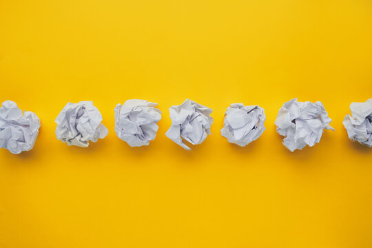 Crumpled paper balls on yellow background. Brain storming and idea concept