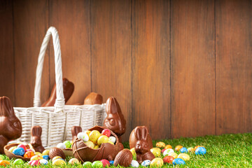 Easter egg hunting background. Various candy and chocolate Easter eggs, bunny and rabbits with...