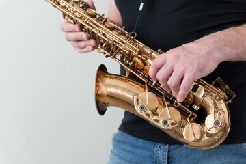 Man in black shirt holds saxophone. Horizontal photo of the musician with copy space
