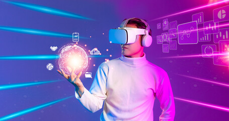 Metaverse technology concept. Asian man wearing white vr headset holding world icon on hologram virtual screen. purple and blue cyber punk background.