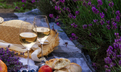 wine, fruits, berries, cheese, glasses picnic in lavender field. Selective focus