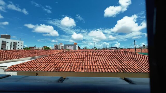 Time lapse from the window of a small apartment looking out at the poor community of Valentina in the beach capital Joao Pessoa in Paraiba, Brazil on a warm sunny summer day.