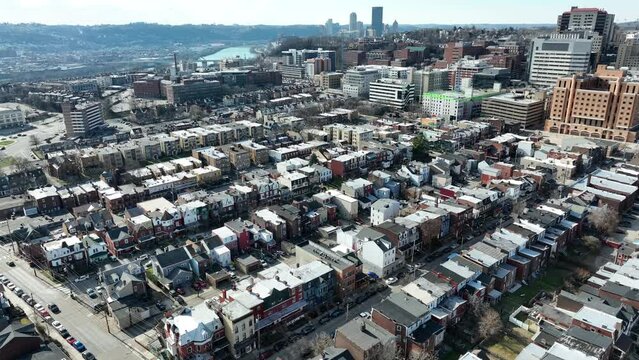 Oakland Pittsburgh neighborhood in winter. High aerial establishing shot of rundown city community. University of Pittsburgh row houses.