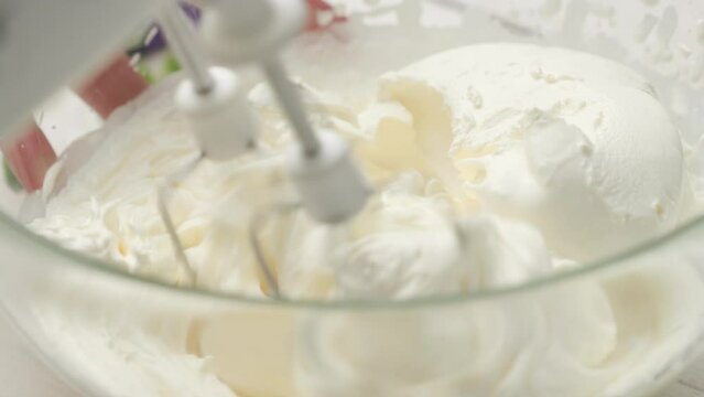 Close up shot of mixing whipped heavy cream with mascarpone cheese, dipping twisters in cream; homemade strawberry dessert
