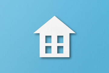 Fototapeta na wymiar White paper cut out house shape isolated on light blue paper background.