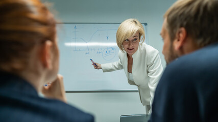 Caucasian woman blonde leads a presentation for colleagues. 