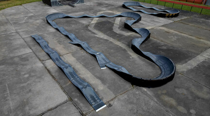 bike path in the car park Pumping (moving up and down) is used instead of pedaling and bouncing to move bicycles, scooters, skateboards and inline skates along the modular pumptrack track, oval, drone