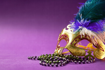 The concept of Masquerade disguise. Purple background with copy space. Mask with green and purple...