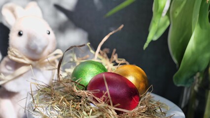 Easter colorful eggs rotate in nest with hey outdoor in sunny warming day.