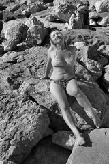 Dojrzała kobieta w bikini na kamienistej plaży - obrazy, fototapety, plakaty