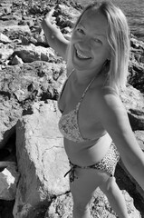 Radosna kobieta w bikini na kamienistej plaży - obrazy, fototapety, plakaty