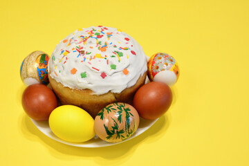 Fototapeta na wymiar A plate of colorful eggs and a cake with sugar sprinkles isolated copy space