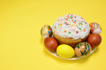 Fototapeta na wymiar A plate of colorful eggs and a cake with sprinkles on it isolated on yellow background