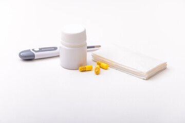 Thermometer, pills, vitamins and tissues on a white background. Home pharmacy