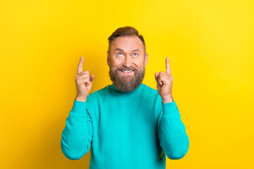 Photo of positive nice man wear stylish clothes look empty space share news opening new boutique isolated on yellow color background