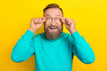Photo portrait of attractive grandpa try on eyewear unbelievable unexpected dressed stylish cyan outfit isolated on yellow color background