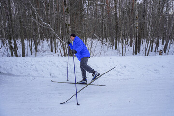 Fototapeta na wymiar man 50 years old skiing in the forest in winter