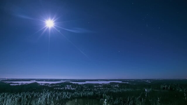 Moon and stars over a winter landscape wilderness - nighttime time lapse
