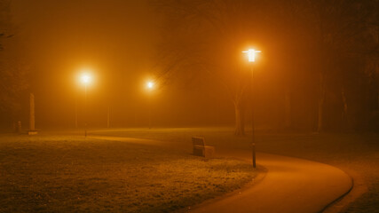 parkway and orange illuminated street lights in the dark and foggy night