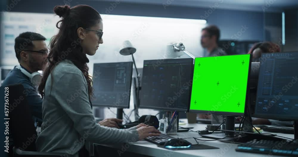 Fototapete Female Software Developer Working on a Desktop Computer with Green Screen Mock Up Display. Busy Specialist Typing on Keyboard, Coding and Implementing a New Technical Feature, Working in an Agency