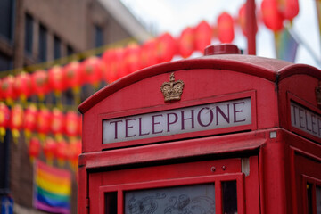 Red call box in London Chinatown (Soho), with LGBT flag in the background