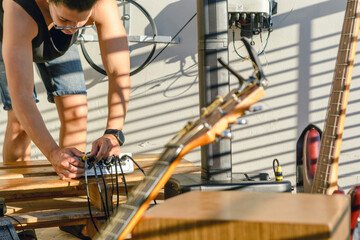 young man connecting cables on music mixer controller, for live music set