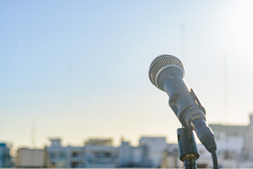 dynamic microphone on a tripod on the terrace of a building, copy space