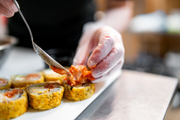 professional chef's hands making sushi and rolls in a restaurant kitchen