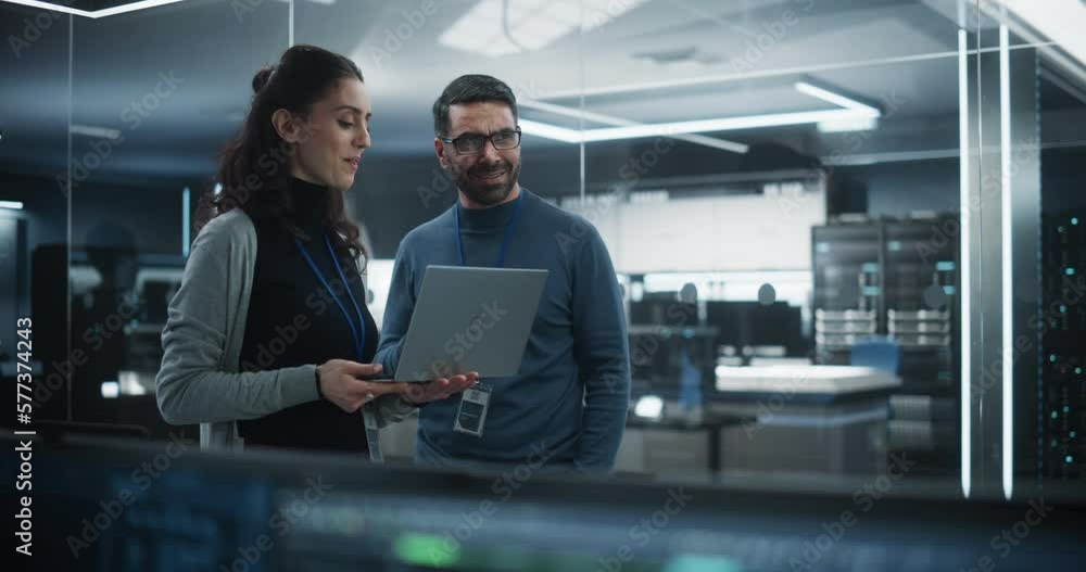 Poster Portrait of Two Happy Female and Male Engineers Using Laptop Computer to Analyze and Discuss How to Proceed with the Artificial Intelligence Software. Casually Chatting in High Tech Research Office