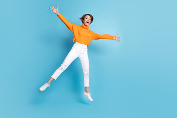 Fototapeta na wymiar Full length photo of lovely young lady fooling have fun jumping star energetic wear trendy orange garment isolated on blue color background