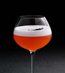 Refreshing alcoholic cocktail with egg foam in a glass