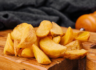 Roasted potato wedges on wooden board