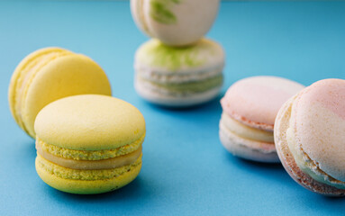 Sweet and colorful macaroons on blue with yellow background