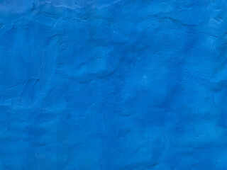 uneven blue wall with blue paint plaster as a background