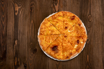 Baked homemade meat pie on wooden background.