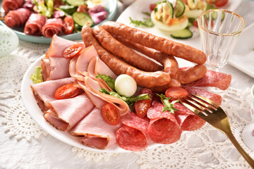 Easter table with a platter of ham and sausages
