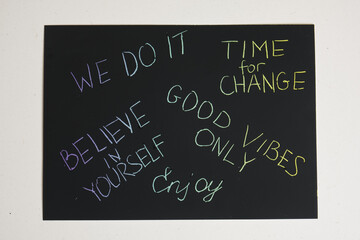 colored motivational slogans are scratched on on a black engraving board
