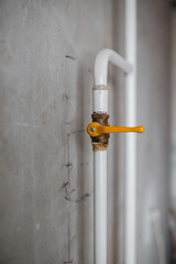 Gas communications in the house - white metal pipes with a yellow ceiling tap - sealed gas meter