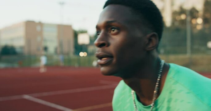 Selective focus african american concentraed basketball player tries to make slam dunk at playground outside playing with friends shows skills.